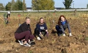 Dr. Boulard planting trees with students